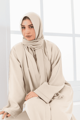 woman sitting wearing fone colour abaya