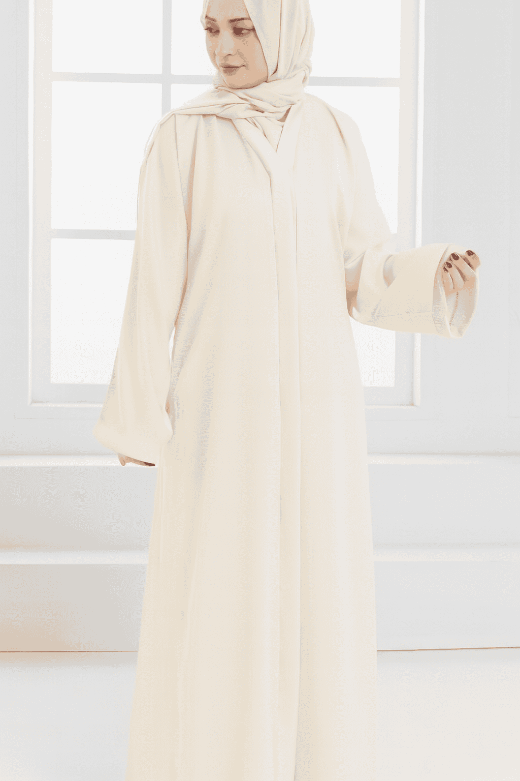 woman standing next to the window with an elegant abaya style