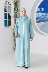 Woman wearing elegant teal abaya in stylish indoor setting