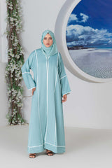 Woman wearing a stylish turquoise abaya in elegant setting